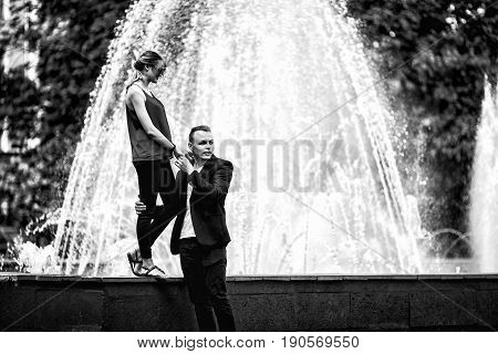 Couple In Love Next To The Fountain On A Sunny Day. Black And White Photo.