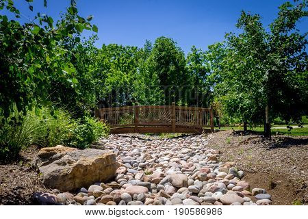 Wooden bridge across small rock creek in the park
