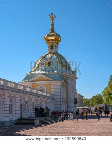 Petergof, Russia - June 5, 2017: The building is a special pantry. The baroque dome is decorated with a double-headed eagle. People go on an excursion.