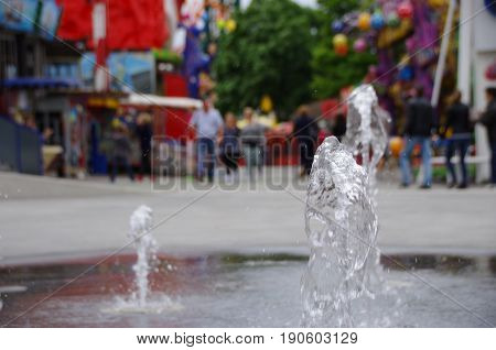 People walking through background of fountain in Vienna Praterstern in Austria