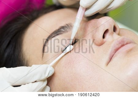 Woman on the procedure for eyelash extensions, eyelashes lamination