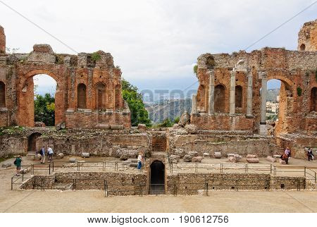 Tourists on the stage of Teatro Greco or Antico, an ancient Greco-Roman theatre still in use - Taormina Sicily Italy, 22 October 2011