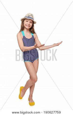 Smiling full length girl in swimsuit showing open hand palm with copy space for product or text