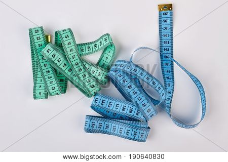 Measuring tapes on white background. Equipment for figure accuracy measurement.
