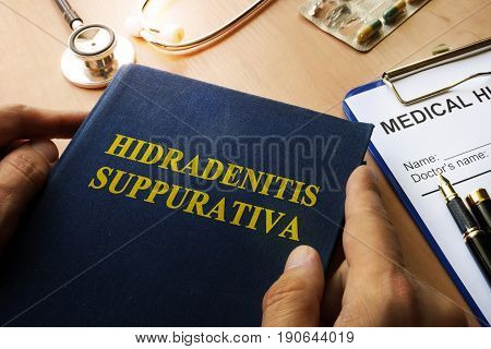 Book with title Hidradenitis Suppurativa on a table.