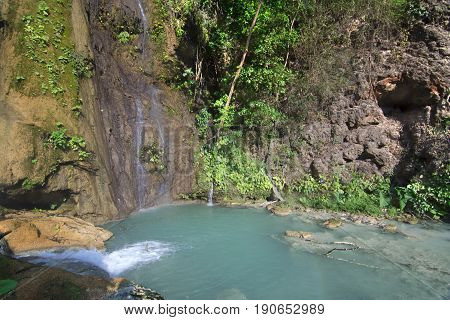 Turquoise blue pool under tranquil waterfalls surrounded by lush green tropical vegetation at La Conchuda waterfall in Rio la Venta Canyon Chiapas Mexico