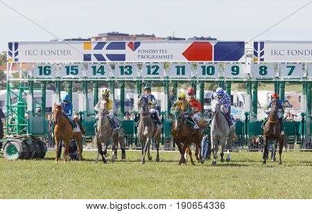 STOCKHOLM SWEDEN - JUNE 06 2017: Start of the gallop race for arabian race horses and colorful jockeys at Nationaldags Galoppen at Gardet. June 6 2017 in Stockholm Sweden
