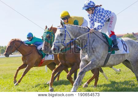 STOCKHOLM SWEDEN - JUNE 06 2017: Three jockeys side by side riding gallop arabian race horses at Nationaldags Galoppen at Gardet. June 6 2017 in Stockholm Sweden