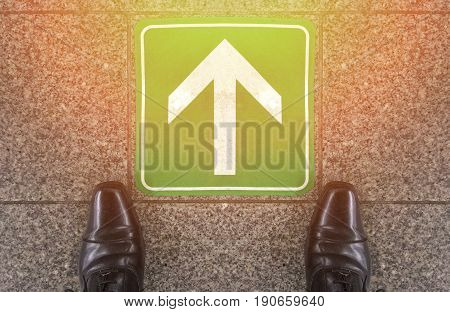 A businessman shoes standing to prepare to go forward to future or success way with go forward narrow sign on marble ground.