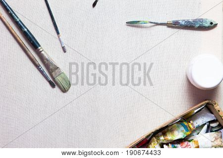 Painter workplace flat lay. Oil paints, brushes, canvas. Artist's equipment assortment background. Drawing lessons, art school, young talent, creativity, DIY concept