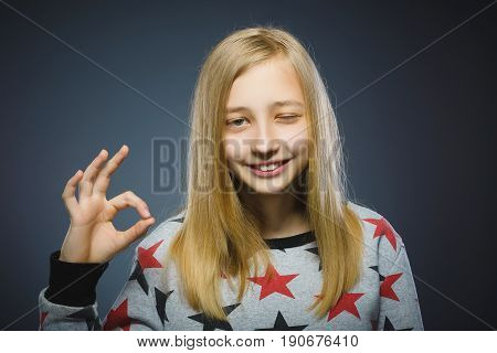 Closeup Portrait of handsome teen show Ok isolate on grey background.