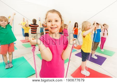 Group of happy 5-6 years old boys and girls having fun with jumping ropes in gym