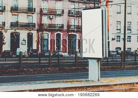 Vertical information banner mock-up near railroad and highway blank information placeholder in evening urban settings white empty city billboard with copy space for logo your text or advertising