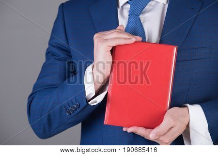 Red Reading Book In Hand Of Young Man Or Businessman