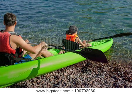Kayaks. Couple kanoeing in the sea near the island with mountains. People kayaking in the ocean.