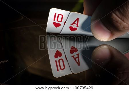a ten and an ACE of spade in the hands of the player in blackjack or poker but a black background