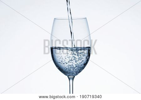 Water poured into glass on white background