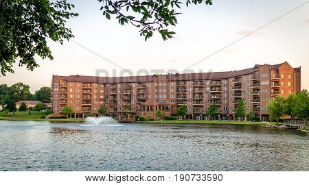 Large brick apartment building infront of a lake