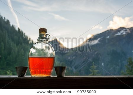 Drinking plum brandy after a long hiking tour in the mountains in Austria during sunset