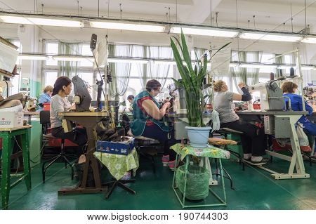 MOSCOW, RUSSIA - FEBRUARY 21, 2017: Moscow shoe factory JSC RALF RINGER . Female and male workers on a sewing machine.