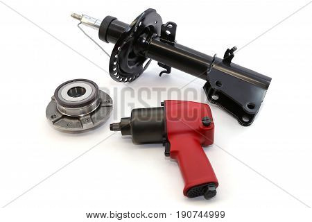 Car dampers and pneumatic impact wrench on white background isolation