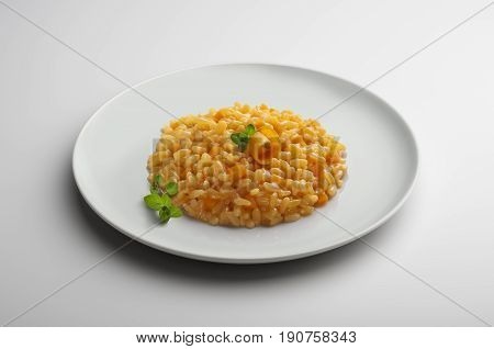 Plate of risotto with pumpkin isolated on white table