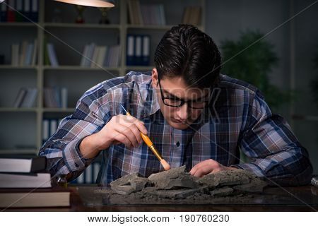 Archeologist working late night in office