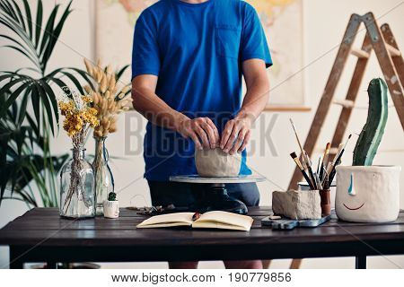 Unrecognizable artisan foreman works on new clay sculpture during arts class performs and teaches techniques needed to work with materials and concrete