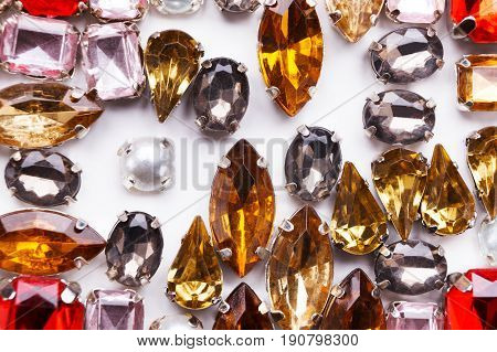 Colorful gemstones variety on white background, free space. Assortment of bright mounted gemstones, jewelry production concept