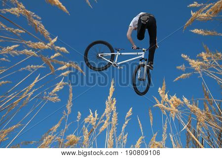 Shot over grass on biker in jump