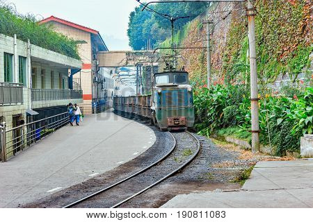 Electric narrow-gauge locomotive with the empty freight train moves through Yuejin town. Jiayang Mining Region. Sichuan province. China