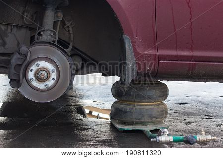 Car lift up by hydraulic waiting for tyre wheel replacement at repair service mounting road assistance