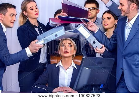 Mad business people office. Team people are unhappy with their leader. Intern woman manager does not cope with his duties. Crazy crowd in stress throw up their chief's papers. Documents for signature.