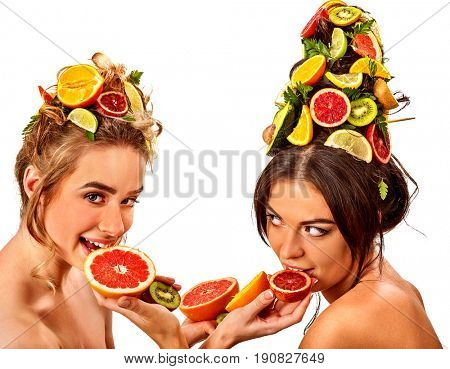 Hair and facial mask and body care from fruits for woman on spa procedure concept. Fresh fruit on two women head and hands for smooth skin. Girls are testing new cosmetics and take spa treatments.