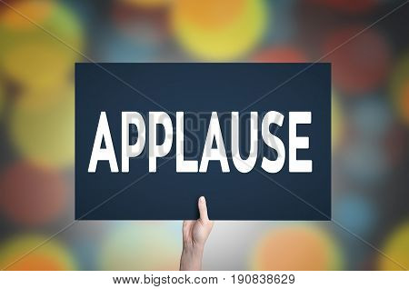 Applause card in hand with bokeh lights background