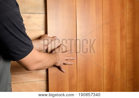 A Man In Construction Clothes Mounts Medium Density Fiberboard Panels On The Wall