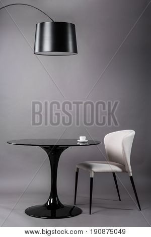 Black table, chair and the floor lamp on gray background. Modern furniture composition for interior