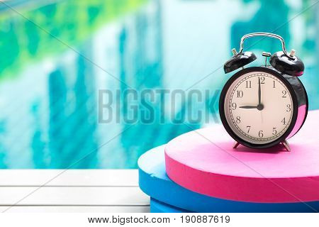 Swimming Times, Retro Black Bell Clock Time At 9 O'clock At Swimming Pool Blur Background.