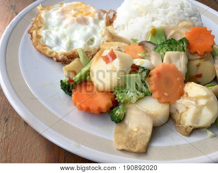 Mixed Fried Vegetable Tofu With Rice And Fried Egg In White Dish On Wooden Background. Vegetarian Fo