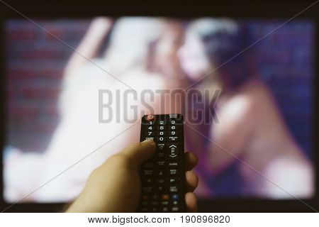 Man watching adult erotic movie on TV.