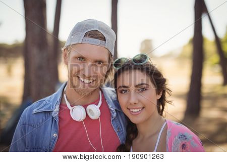 Portrait of smiling couple standing against trees at forest