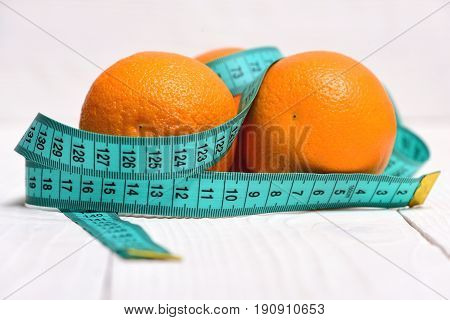 Blue Measuring Tape Wrapped Around Oranges