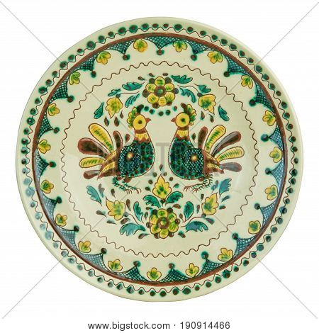 Covered with glaze ceramic plate handmade. Drawing on a plate - the cock. Painting in the technique Kosovo ceramics - it really authentic Ukrainian technique of painting on clay. Isolated on a white background