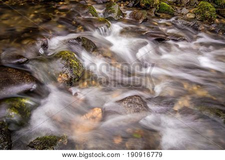 Water In A Stream Cascading Over Some Rocks