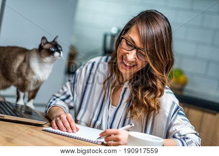 Young Woman Drinking Coffee And Working At Home