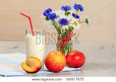 Glass Of Yogurt  With Mint And Fresh Nectarine, Chamomile And Cornflowers In Vase On The Table