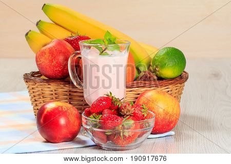 Glass Of Yogurt  With Mint And Fresh Strawberries, Nectarine, Lime, Banana On The Table