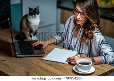 Young Woman Drinking Coffee And Working At Home