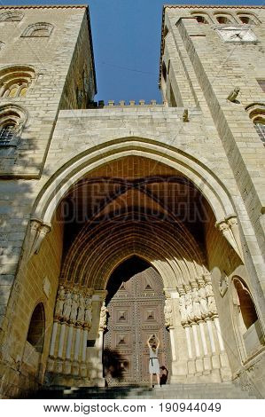 Evora, Alentejo, Portugal, 26-September-2007: A woman standing at the gate of a breathtaking building in Evora.
