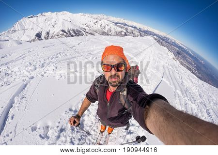 Adult Alpin Skier With Beard, Sunglasses And Hat, Taking Selfie On Snowy Slope In The Beautiful Ital